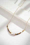 Collier doré perles nacrées et pierre œil de tigre acier